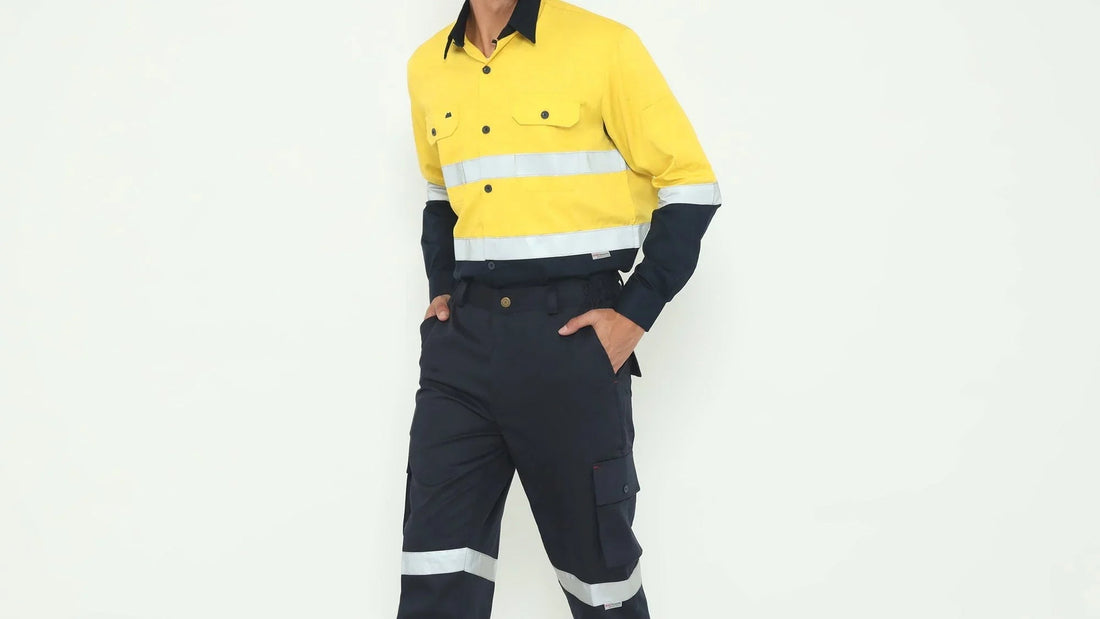 Man wearing yellow and navy high-visibility shirt and navy cargo pants with reflective stripes