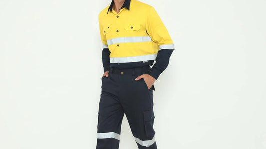 Man wearing yellow and navy high-visibility shirt and navy cargo pants with reflective stripes