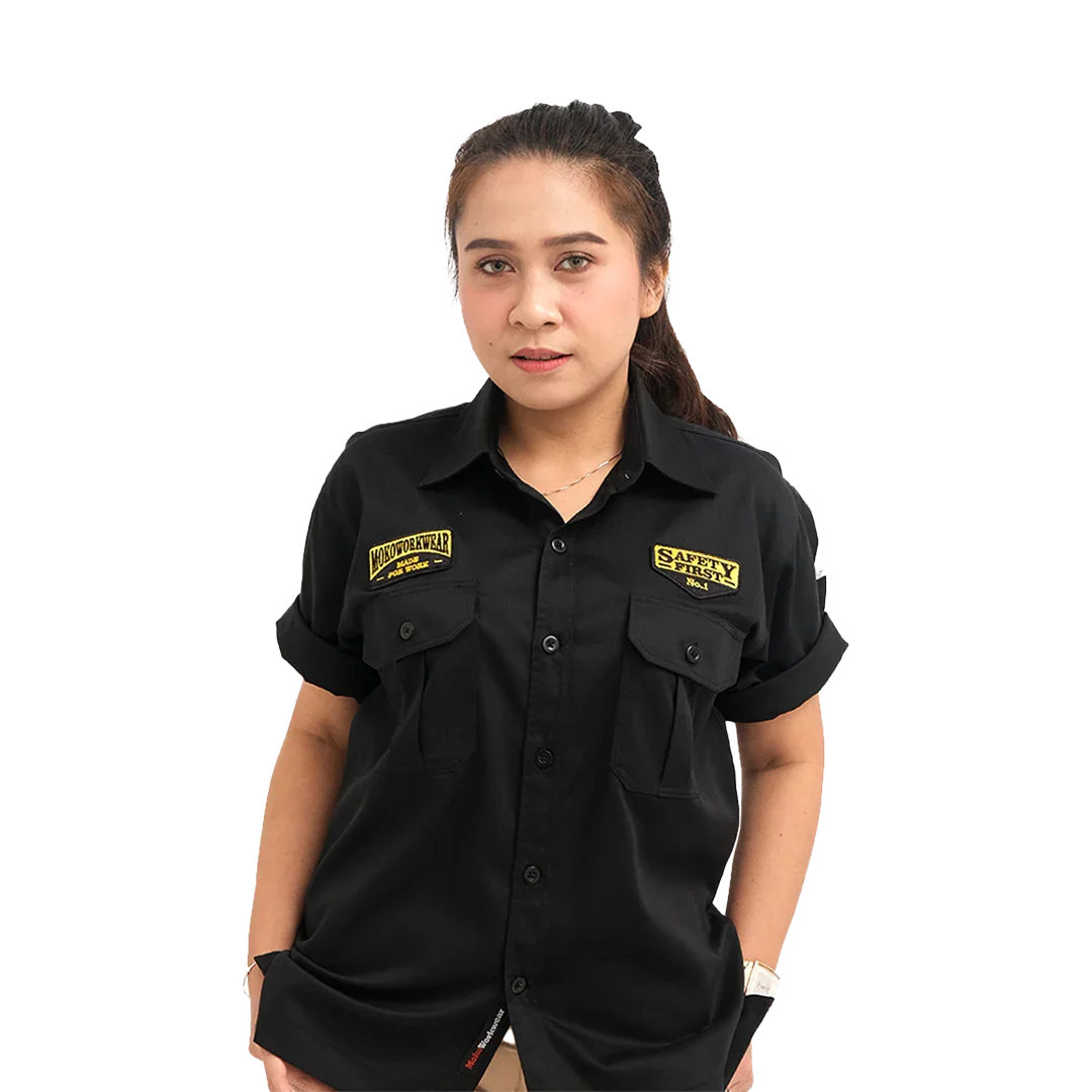 Woman in black short-sleeve button-up shirt with yellow Safety First and Motoworkwear patches