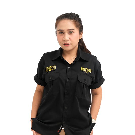 Woman in black short-sleeve button-up shirt with yellow Safety First and Motoworkwear patches